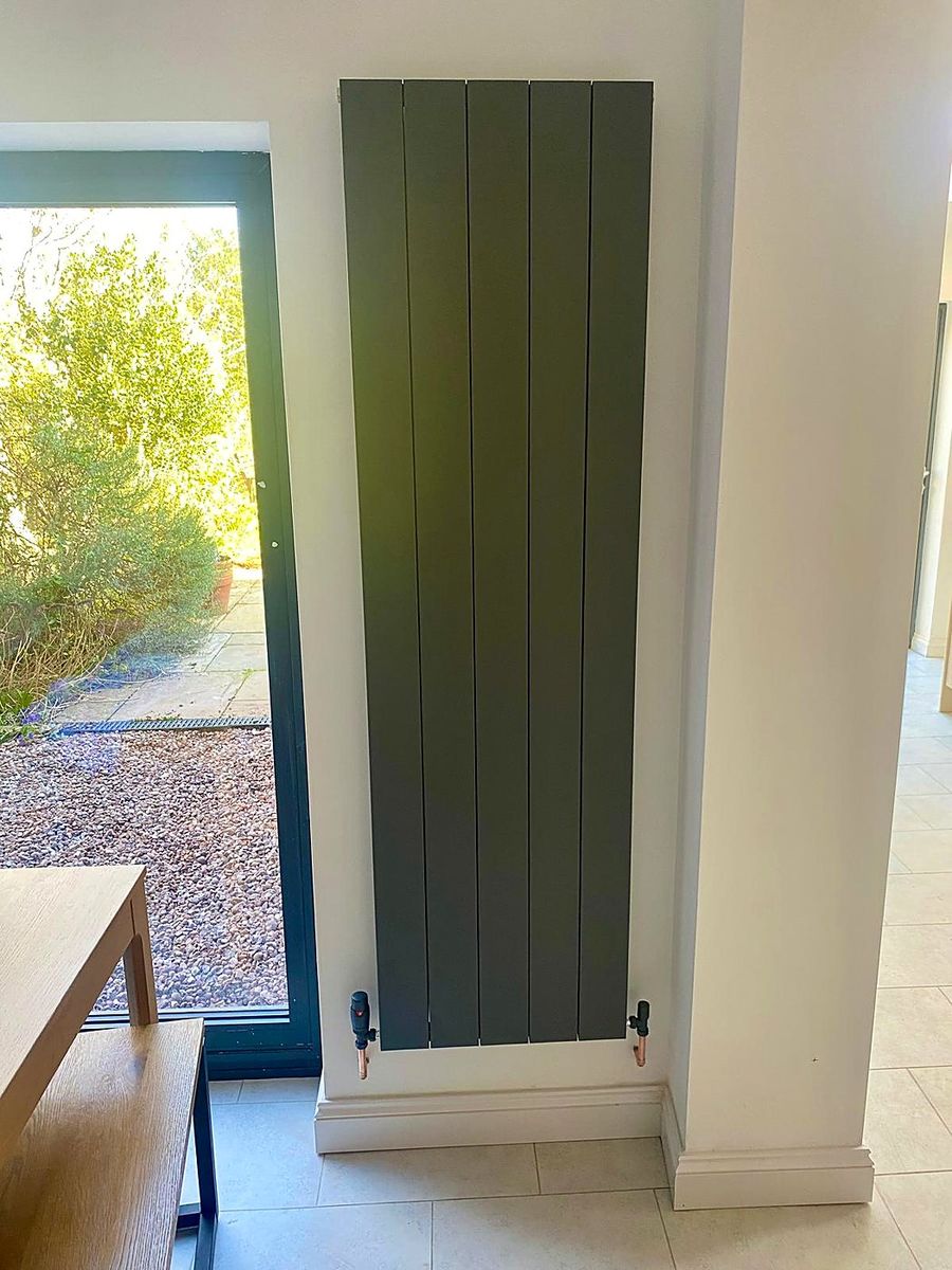 Tall anthracite designer radiator fitted in a kitchen
